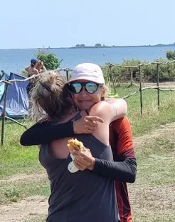 Instructor hugs students after a kitesurfing session